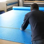 Personne mesurant une bâche à bulle pour apprendre comment coudre une bâche à bulle