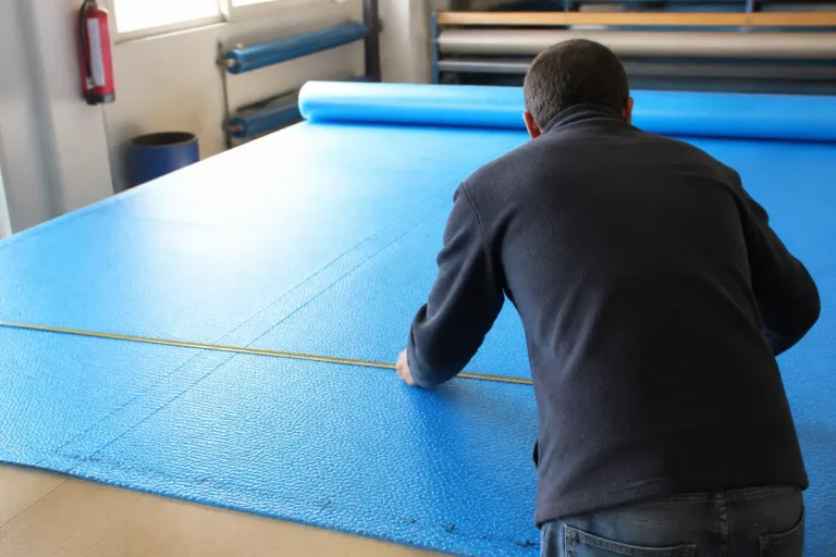 Personne mesurant une bâche à bulle pour apprendre comment coudre une bâche à bulle