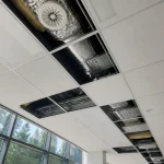 Panneaux de faux plafond retirés, révélant gaines de ventilation et isolation dans un bureau.