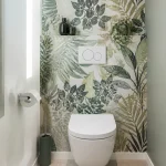 Toilettes modernes avec papier peint de feuillage tropical et accessoires minimalistes vert foncé