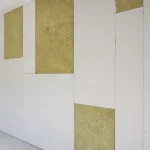 Plaques de placo isolant installées sur un mur intérieur en construction.
